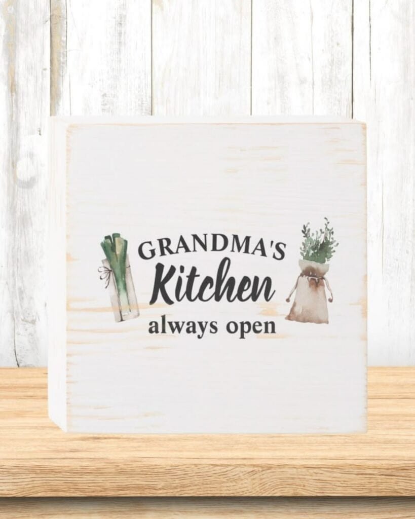 Cute sign painted on a painted white piece of wood saying Grandma' kitchen
